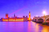 Fototapeta Londyn - View of the Houses of Parliament and Westminster Bridge along River Thames in London at dusk.