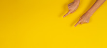 Child Hands Fingers Pointing On Yellow Background