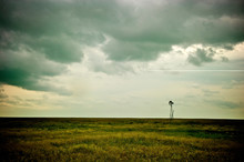 A Windmill Sits Under Storming Skies In The Badlands At Dinosaur Provincial Park In Alberta, Canada.