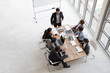 © comzeal - Top view of group of multiethnic busy people working in an office, Aerial view with businessman and businesswoman sitting around a conference table with blank copy space, Business meeting concept
