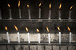 © Cavan Images - Two rows of burning candles.