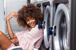 © Samuel B. - Young black African American woman waiting her clothes to be washed in a automatic laundry