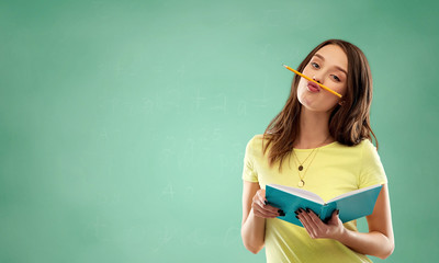 education, school and people concept - teenage student girl in yellow t-shirt with diary or notebook