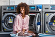 © Samuel B. - Young black African American woman washing her clothes in a automatic laundry