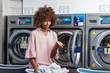 © Samuel B. - Young black African American woman washing her clothes in a automatic laundry