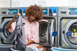 © Samuel B. - Young black African American woman washing her clothes in a automatic laundry