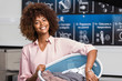 © Samuel B. - Young black African American woman holding a basket of clothes to be washed in a automatic laundry