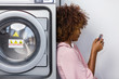 © Samuel B. - Young black African American woman waiting her clothes to be washed in a automatic laundry
