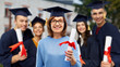 © Syda Productions - graduation, education and old age concept - happy senior graduate student woman in mortar board with diploma next to young people over university campus background
