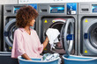 © Samuel B. - Young black African American woman washing her clothes in a automatic laundry