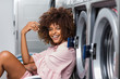 © Samuel B. - Young black African American woman waiting her clothes to be washed in a automatic laundry