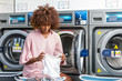 © Samuel B. - Young black African American woman washing her clothes in a automatic laundry