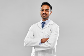 medicine, science and profession concept - smiling indian male doctor or scientist in white coat ove