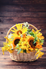 Wall Mural - Spring flowers in basket on brown wooden table