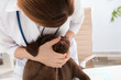 © New Africa - Professional veterinarian examining puppy's teeth in clinic