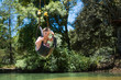 © Cavan Images - Boy riding zip line over water, Rancho Santa Elena, Hidalgo, Mexico