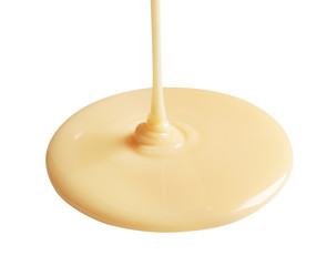 Tasty pouring condensed milk on white background. Dairy product
