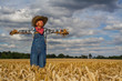 Caucasian man dressed as a scarecrow in a wheatfield