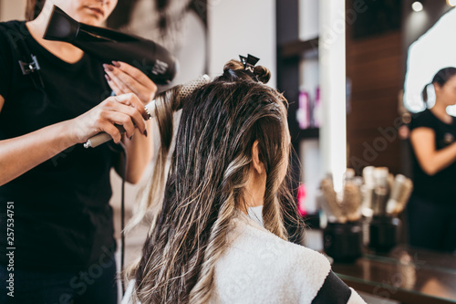 Fotomural Beautiful brunette woman with long hair at the beauty salon getting a hair blowing