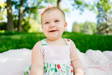 Closeup Portrait Of A Baby Girl Laughing On A Blanket Outside