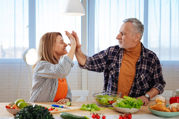 Wife giving high five to her husband after cooking together