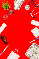 work desk of doctor in hospital with medical set frame on red background top view mockup