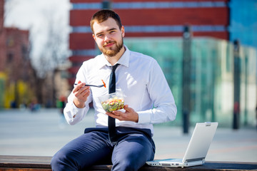 businessman in shirt and tie with salad lunch box