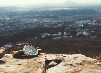 The compass lies on a stone on the edge of a cliff in the mountains