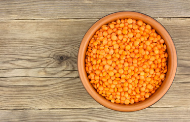 Wall Mural - Red lentils in plate on wooden background