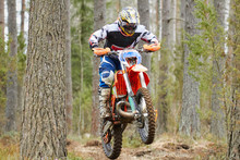 Motocross Driver Jumping With The Bike At High Speed On The Race Track.