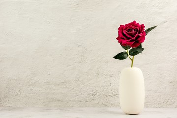 Sticker - red rose in white ceramic vase on the table.