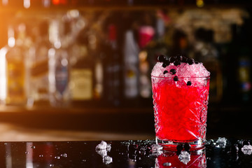 Sticker - blackcurrant cocktail with ice on forward bar background