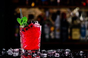 blackcurrant cocktail with ice on forward bar background