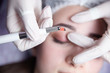 Permanent Makeup For Eyebrows. Microblading brow. Beautician Doing Eyebrow Tattooing For Female Face. Beautiful young girl in a beauty salon