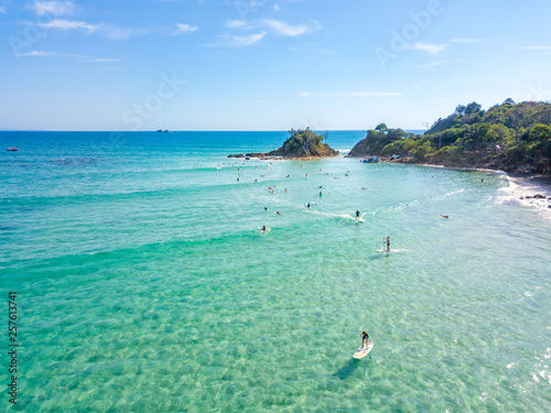 Fotografía The Pass at Byron Bay from an aerial view with surfers and blue water