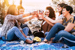 © simona - Group of happy cheerful young women enjoy and celebrate the friendship toasting with wine glasses and smiling together - sunny light in background for friendship concept in outdoor beach