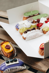 Wall Mural - Set of delicious eclairs with glaze in box, colorful dessert