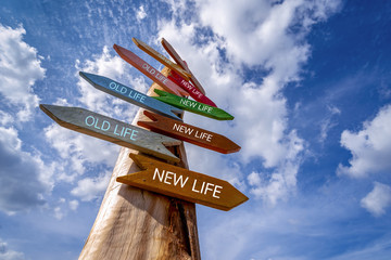 Crossroad signpost with arrows old life and new life pointing in two opposite directions