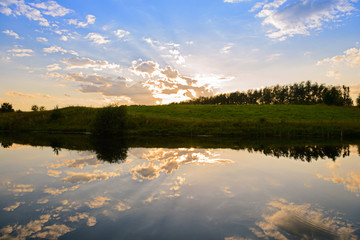 Wall Mural - evening summer landscape with reflection of clouds in a pond