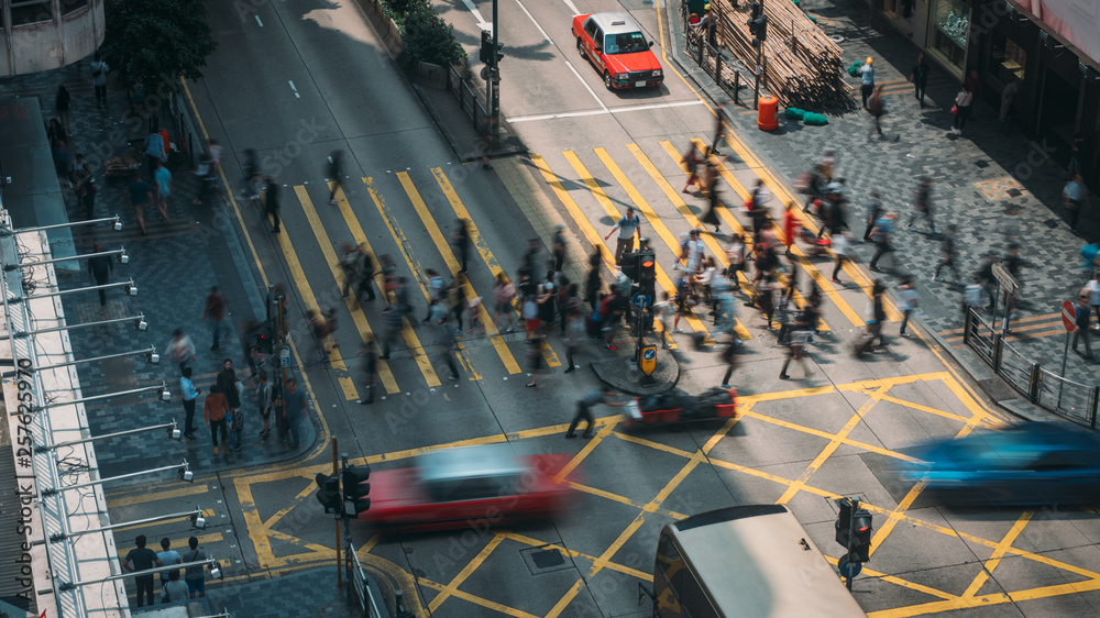People and taxi cabs crossing a very busy crossroads in Tsim Sha Tsui district Hong Kong, China - obrazy, fototapety, plakaty 