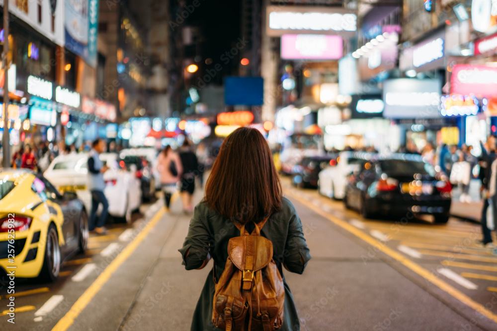 Young woman traveler traveling into Mongkok street market at night in ...