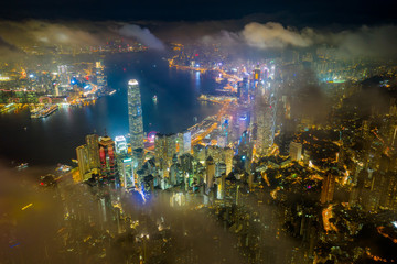 Wall Mural - Aerial view of Hong Kong City skyline at night over the clouds
