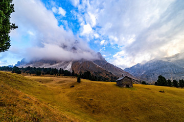 Wall Mural - Wooden rural farmer's shed (hut) in Seiser Alm meadow in the Dolomites, North Italy, Sudtirol (Trentino / Alto Adige). Scenic autumn view of a big valley in the Alps Mountains.