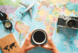 © Alessandro Biascioli - Top view of young woman planning her vacation using world map while drinking coffee - Tourist pointing the next travel destination - Concept of adventure, tourism, and traveling people lifestyle