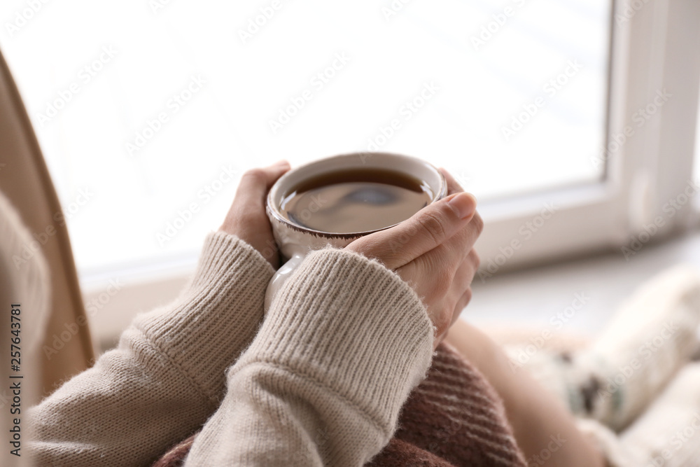 Young woman drinking hot tea at home, closeup - obrazy, fototapety, plakaty 
