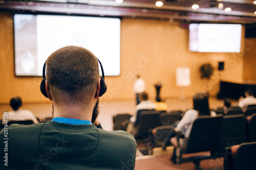 Cuadros en Lienzo Business man is listen seminar at conference using headphones for translation