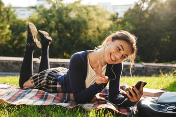 Wall Mural - Pretty teenage girl laying on a grass at the park