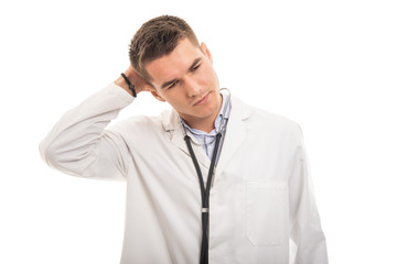 Portrait of young handsome doctor holding head like hurting