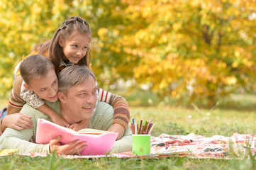 Sticker - Portrait of family resting in park with book