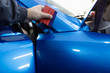© hedgehog94 - Car wrapping specialist putting vinyl foil or film on car. Selective focus.